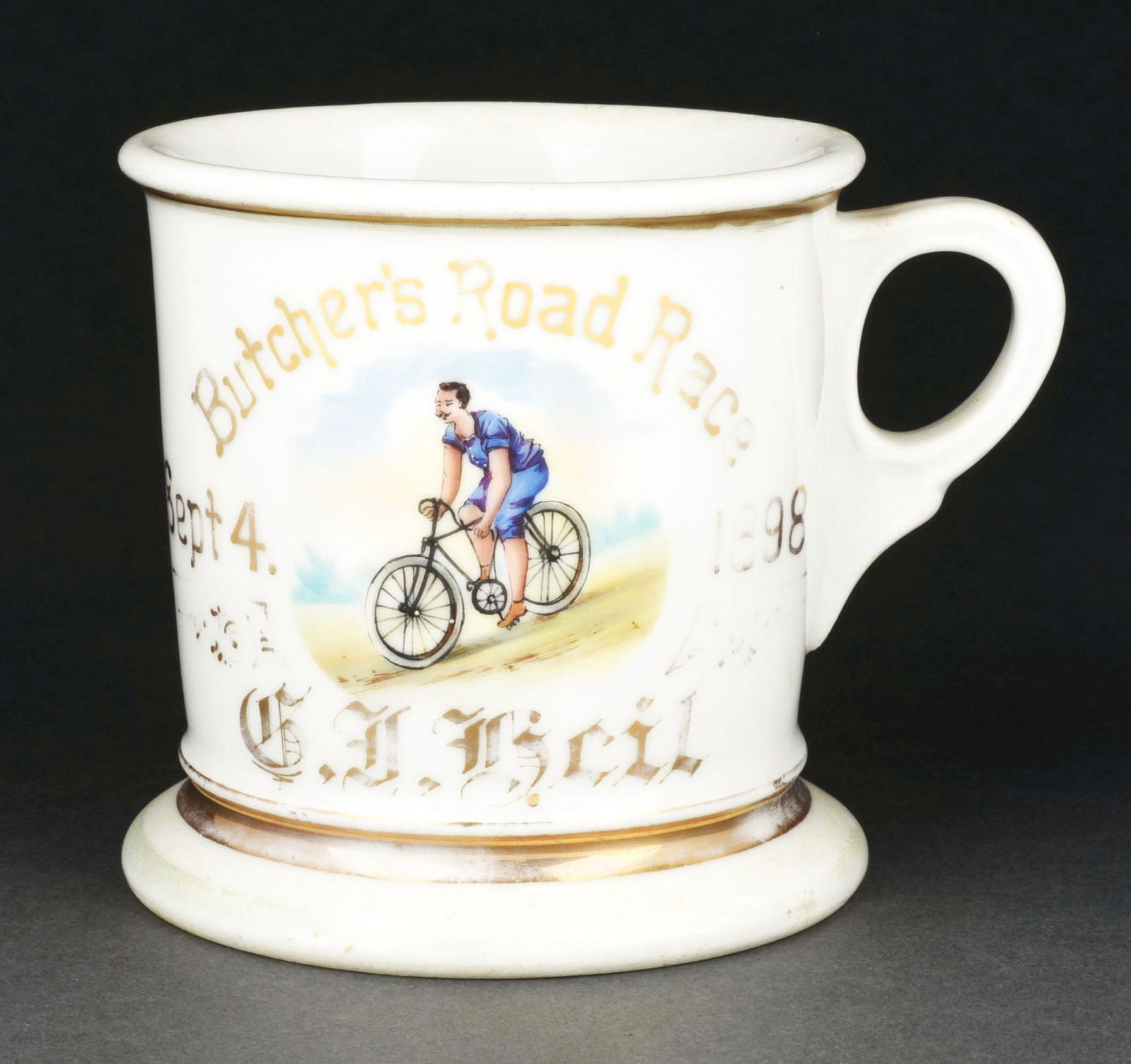 MAN RIDING BICYCLE SHAVING MUG: Has the words "Butcher's Road Race 1898" with the name "G.J. Beil" in gold gilt. Mug is stamped "Limoges France Koken Supply" under base. Nice image of man riding bicycle. Condition: (Excellent) Item