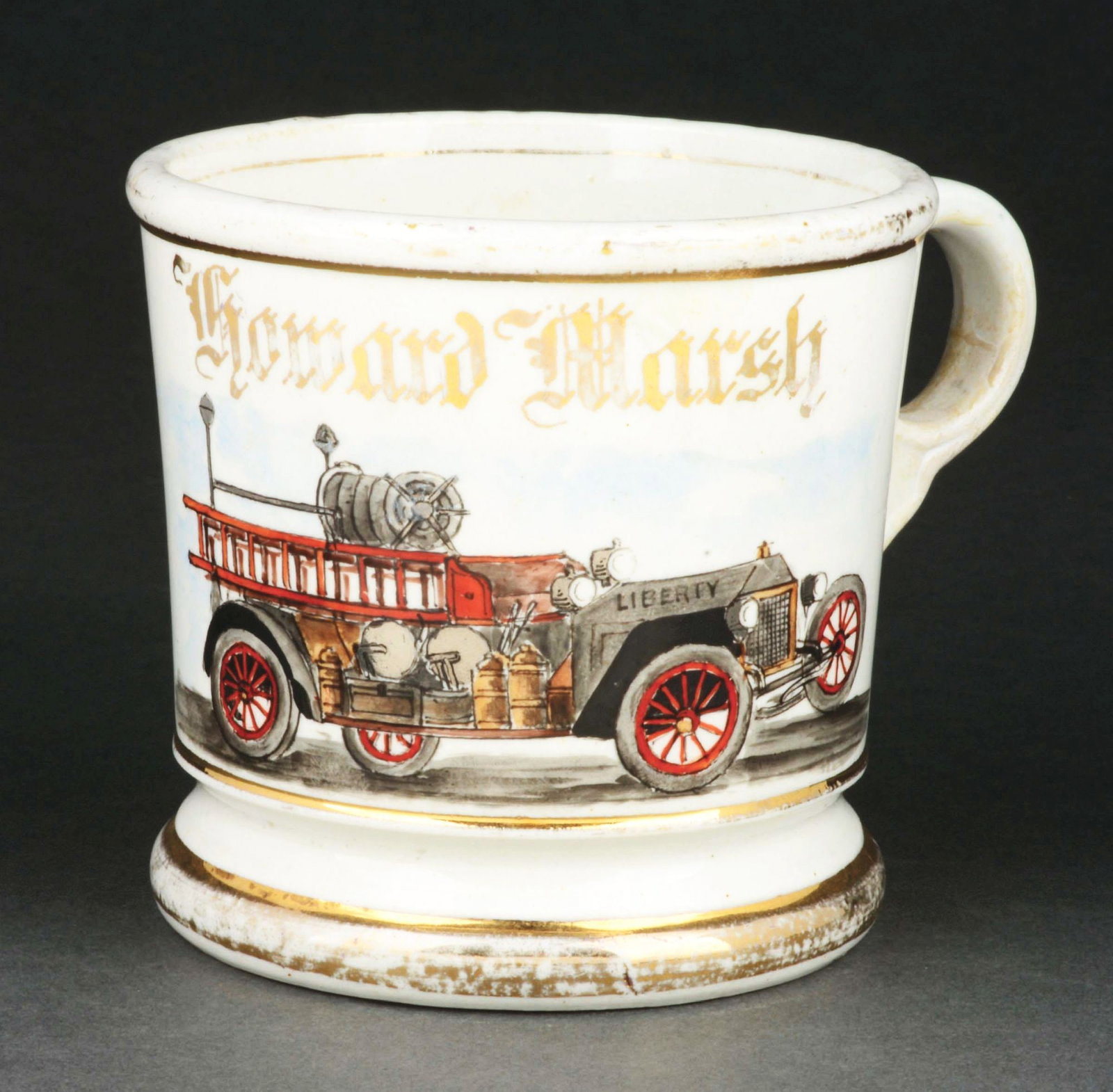 FIREFIGHTER TRUCK SHAVING MUG.: Has the name "Howard Marsh" in gold gilt. Signed "C.L. Hain & Gold" under base. Unique image of Liberty firefighting truck. Condition: (Excellent). Item Dimensions: 4 - 3/4" x 3 - 3/4" x 3 - 3/4".