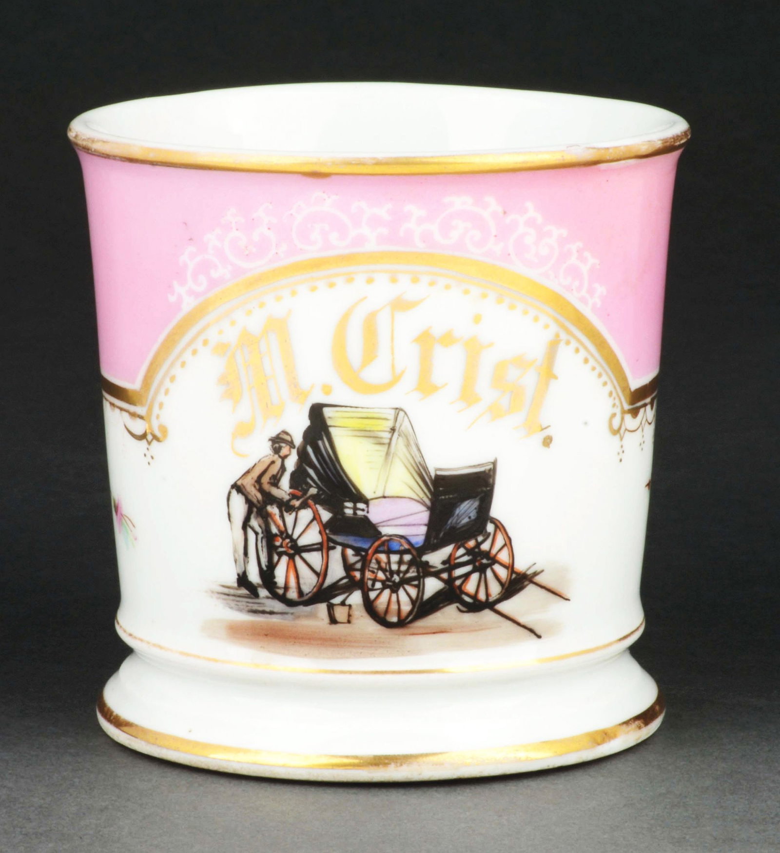 CARRIAGE PRODUCER SHAVING MUG.: Has the name "M. Crist" in gold gilt. Pink wrap on upper-part of mug. Stamped "D&C" under base. Detailed image of man manufacturing a cart. Condition: (Excellent). Item Dimensions: 4 - 1/2" x 3 - 1/2"
