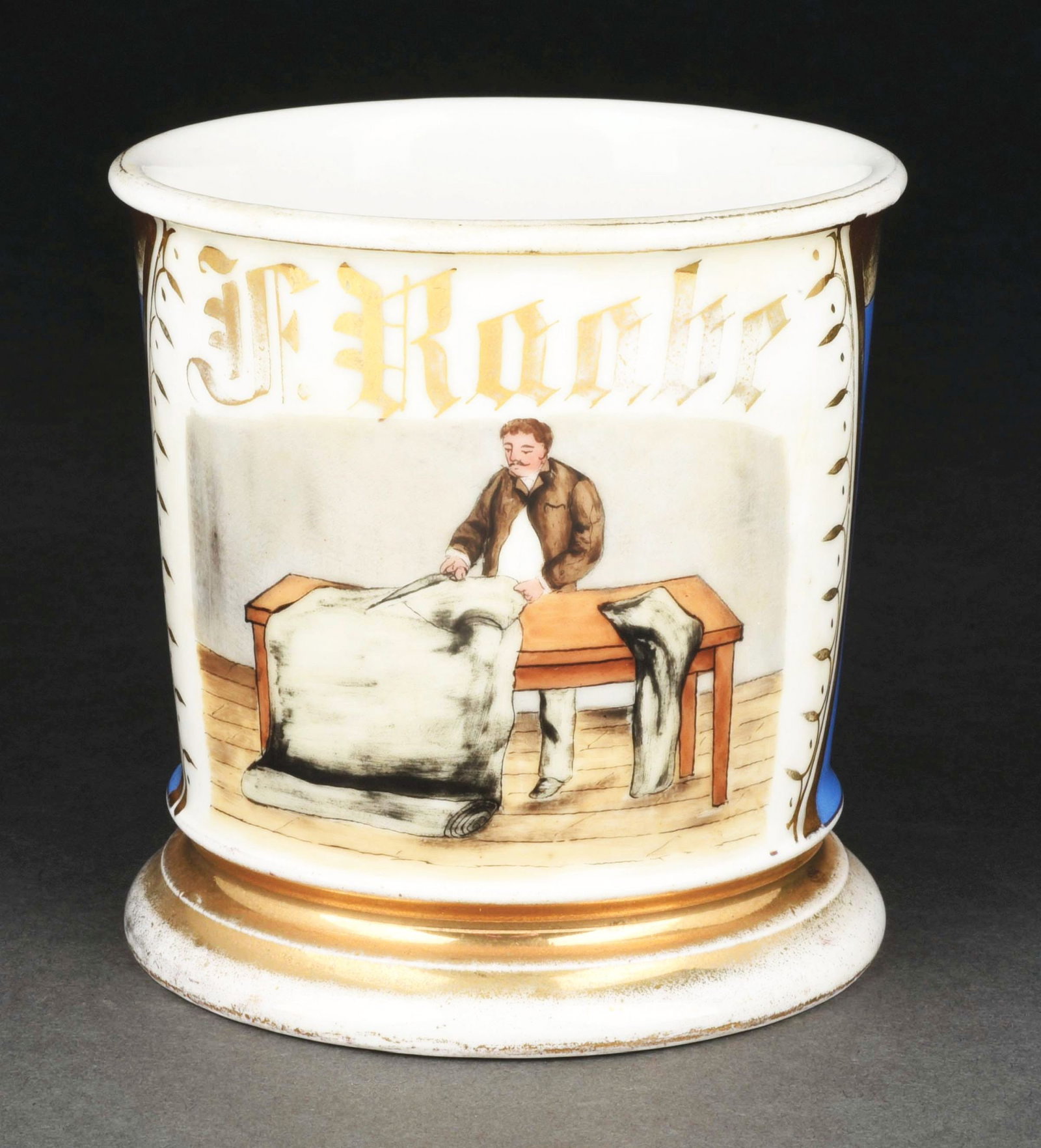 TAILOR SHAVING MUG.: Has the name "F. Roobe" in gold gilt across the front. Blue wrap. Mug is stamped "T&V France." Condition: (Excellent). Item Dimensions: 4 - 1/2" x 3 - 1/2" x 3 - 1/2".