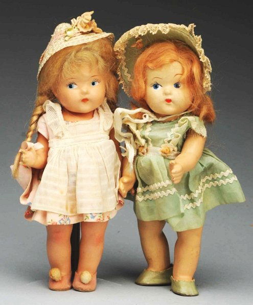 Lot of 2: Vogue “Toddles” Dolls.: All composition marked Vogue, painted side-glancing eyes, original mohair wigs (light crazing on faces). Girl in tagged green organdy with tagged dress, matching panties and bonnet, no socks. Girl in