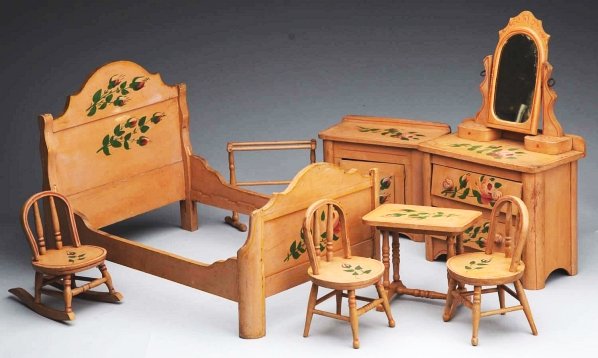 Doll’s Painted Eight-Piece Bedroom Set.: Commercially made set with painted pink roses and green leaves with red stencil outlining. Bed, dresser with mirror and drawers, clothes rack, two side chairs, rocking chair, table and washstand. Cond