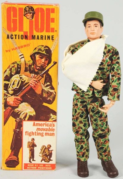 Hasbro GI Joe Action Marine Figure.: American. Circa 1964. Painted scar on right cheek. Includes original box with arm sling, hat, boots, and boot removal instruction sheet. Box marked "7700" and has some creasing and paper loss where th