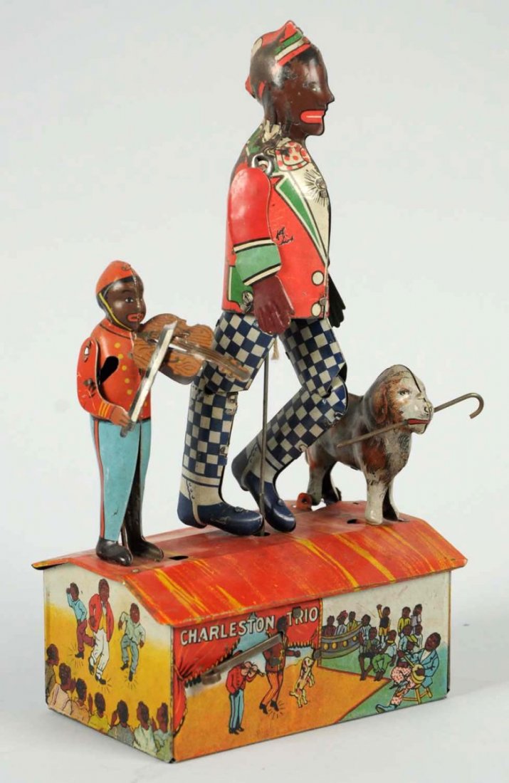 Tin Marx Charleston Trio Dancing Wind-Up Toy.: American. Working. Depicts roof dancer, violin player, and dog. Original arms. Some scratching and litho loss to middle figure and denting to roof. Condition (Good - Very Good). Size 9 - 3/4" T. CORRE