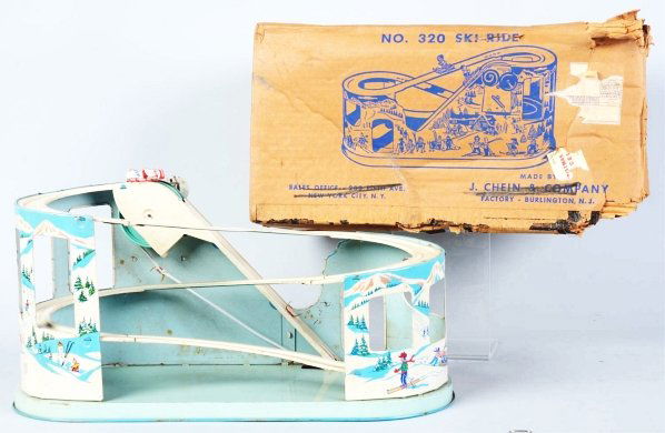 Tin Litho Chein No. 320 Ski Ride Wind-Up Toy.: American. Needs adjustment to elastic in order to operate correctly. Toy has very nice lithography and comes with one scarce toboggan car. Includes partial original box missing end flaps on one side a