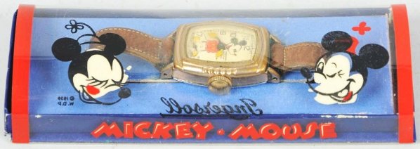 Walt Disney Mickey Mouse Character Wrist Watch.: Circa 1939. Made by Ingersoll. Working. Unusual watch has a gold-plated and fluted bezel. On this model the three Mickey's were replaced with numerals. Some wear to band and bezel. Includes very rare