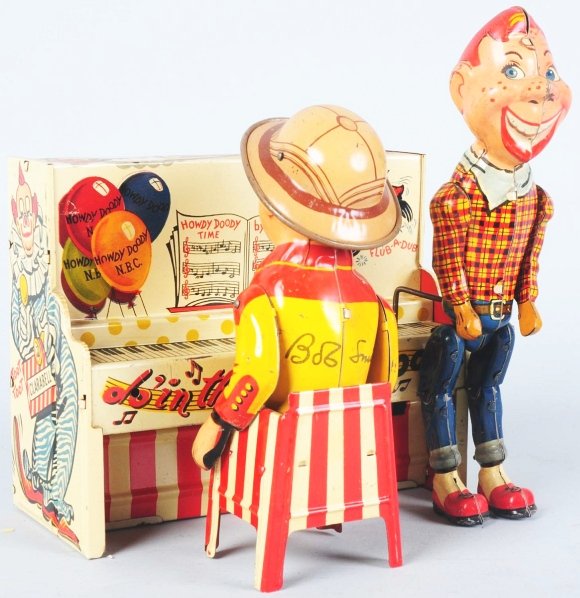 Tin Unique Art Howdy Doody & Bob Smith Band Toy.: American. Wind-up mechanism is working. Depicts Howdy Doody dancing in front of piano while Bob Smith plays. Shows the peanut gallery on the back along with depictions of other Unique Art toys. Some m