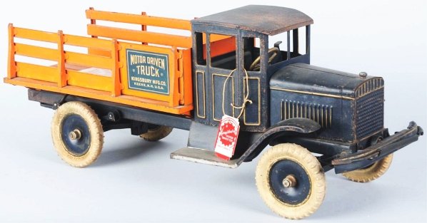 Pressed Steel Kingsbury Motor-Driven Stake Truck.: Working crank motor and staring lever beside driver's seat. White rubber tires with nice decals on both sides of rear. Some paint loss and wear throughout, especially to cab roof and fenders. Replacem