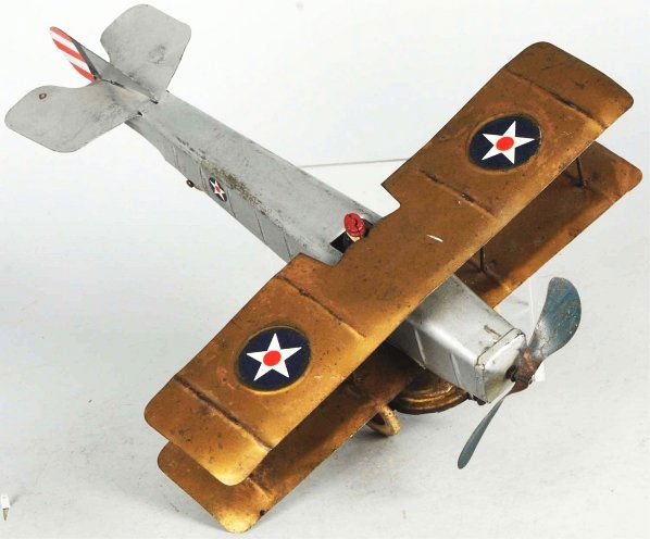 Pressed Steel Kingsbury Airplane Wind-Up Toy.: Bi-wing version. Original prop and tail fins. Includes pilot, white rubber tires, and replaced nut holding wing to plane body. Some overall scratching and wear. Condition (Very Good - Excellent). Size