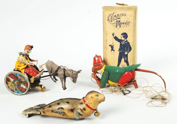 Lot of 3: Tin Litho Lehmann Animal Toys.: German. Includes one pull-cord Climbing Monkey in original box, one wind-up Seal with original bell, and one Balky Mule cart toy with some litho loss to clown's arms. Condition (Very Good - Excellent)