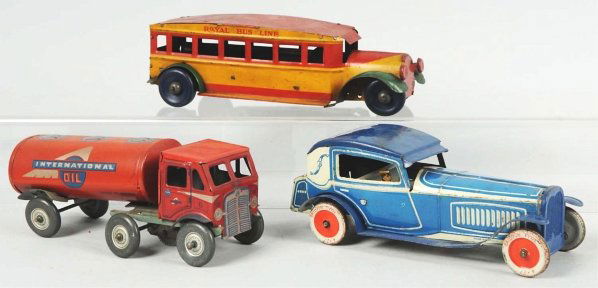Lot of 2: Tin Litho Vehicle Wind-Up Toys.: Includes one German tin car with lithographed driver and one English Mettoy International Oil Tractor Trailer. Some scratching and wear to hood and roof of German car. Condition (Very Good). Size Larg