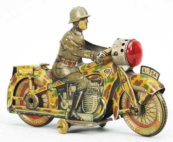 Tin Litho Motorcycle Wind-Up Toy.: German. Working. Military version. Marked "CKAO" and "A-754" on front fender. Replacement plastic headlight piece and some moderate scratching and wear throughout. Condition (Very Good). Size 7 - 1/2"