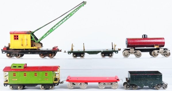 Lot of 6: Lionel Standard Gauge Freight Cars.: American. Tinplate. Includes flat car with replacement trucks, lumber car, crane car, caboose, hopper car, and tank car. Various conditions. Condition (Very Good).