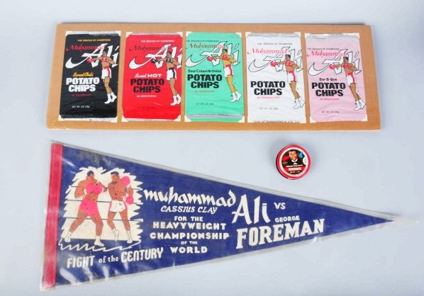 Lot of 4: Muhammad Ali Memorabilia Items.: Includes one original Ali vs. Foreman Heavyweight Championship pennant, one can of endorsed shoe polish, one figural liquor bottle with stopper, and one set of five endorsed potato chip bags. Conditio