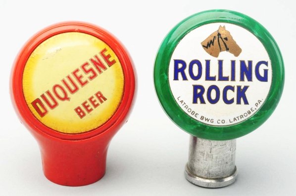 Lot of 2: Rolling Rock & Duquesne Beer Tap Knobs.: The Duquesne tap knob has discoloration to face but is clean overall and the Rolling Rock tap knob has a clean and bright face with overall wear, some scratching, and a clean tap. Condition (Good - Ve