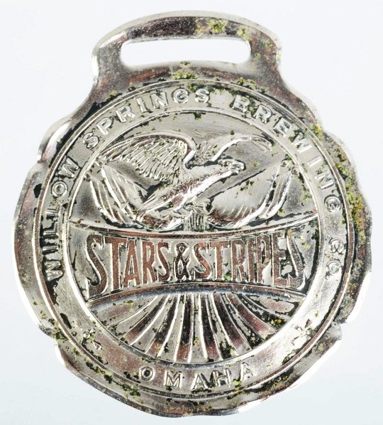 Stars & Stripes Beer Fob.: Willow Springs Brewing Company in Omaha, NE. Embossed "Stars & Stripes Beer" on back. Nice detail with some light tarnishing on front and back. Condition (Very Good). Size 1 - 3/4" T.