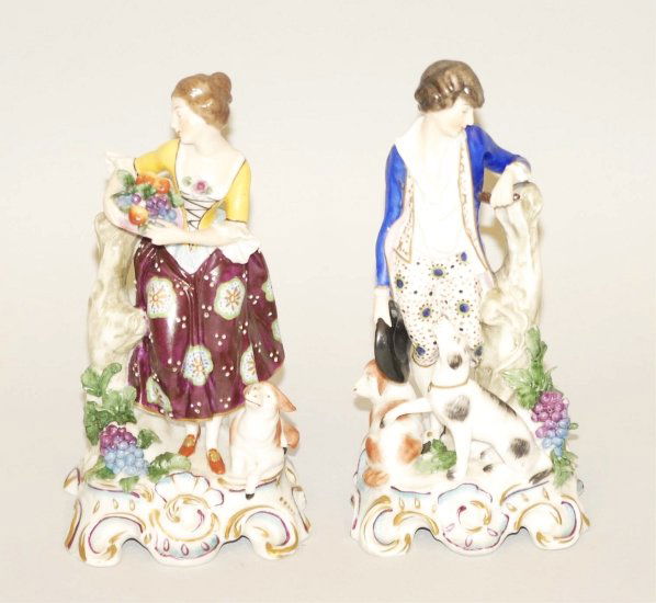 Lot of 2: Staffordshire Figurines.: Includes one woman carrying fruit with dog and one man with two dogs. Light wear overall. Condition (Very Good). Size Each: 7 - 1/4" T.