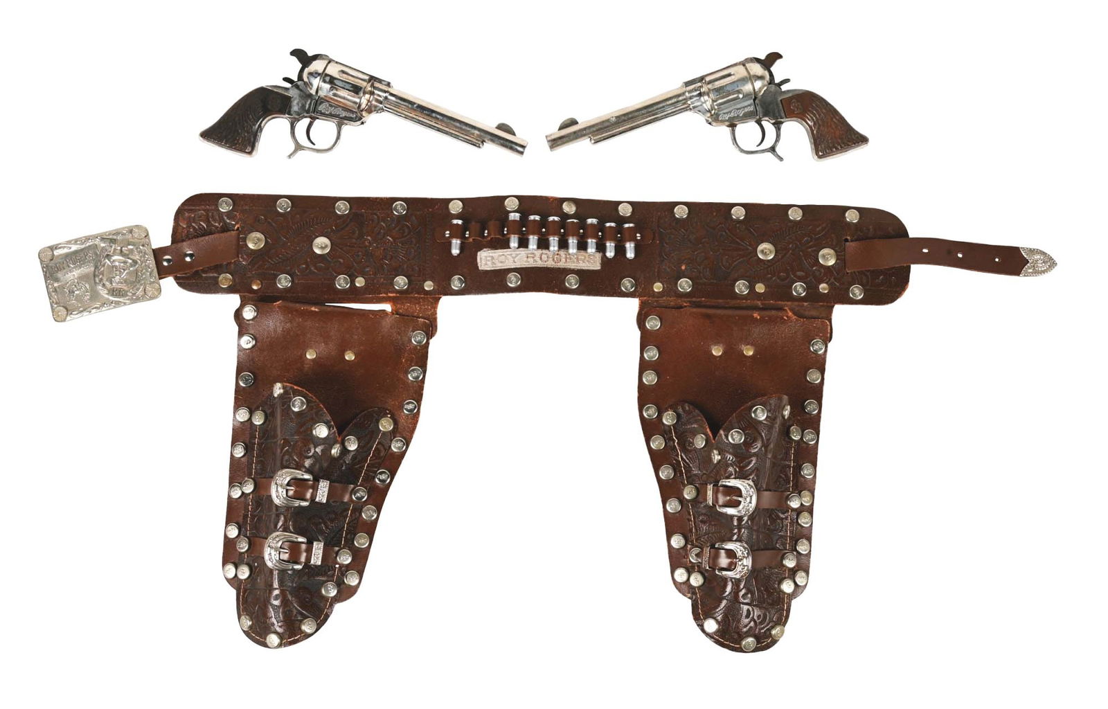 1950S ROY ROGERS DOUBLE-GUN SET: Includes eight plastic bullets and two matching guns, marked "Roy Rogers." Look like Schmidt guns. Includes original holster with belt buckle. Marked "Roy Rogers and Trigger." Condition: (Very Good -