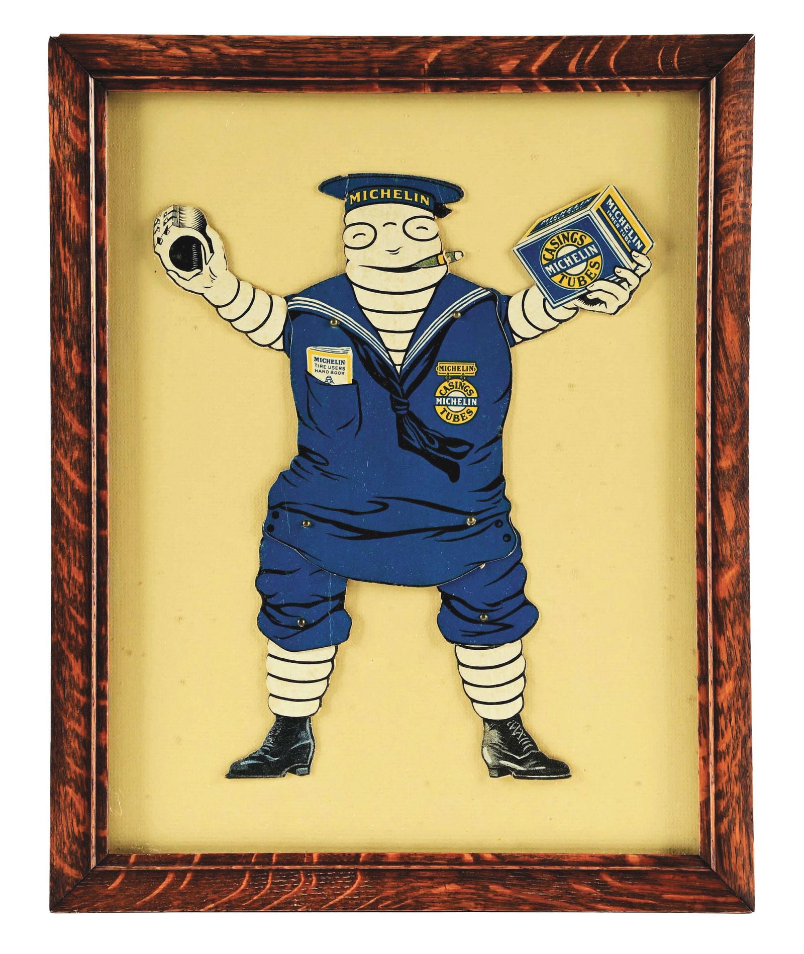 MICHELIN TIRES FRAMED ARTICULATING BIBENDUM DISPLAY W/ OAK FRAME.: Single Sided Card Stock Michelin Tires Bibendum Articulating Display framed behind glass with period correct oak frame. CONDITION: Display is overall excellent showing light wear and minimal creases t