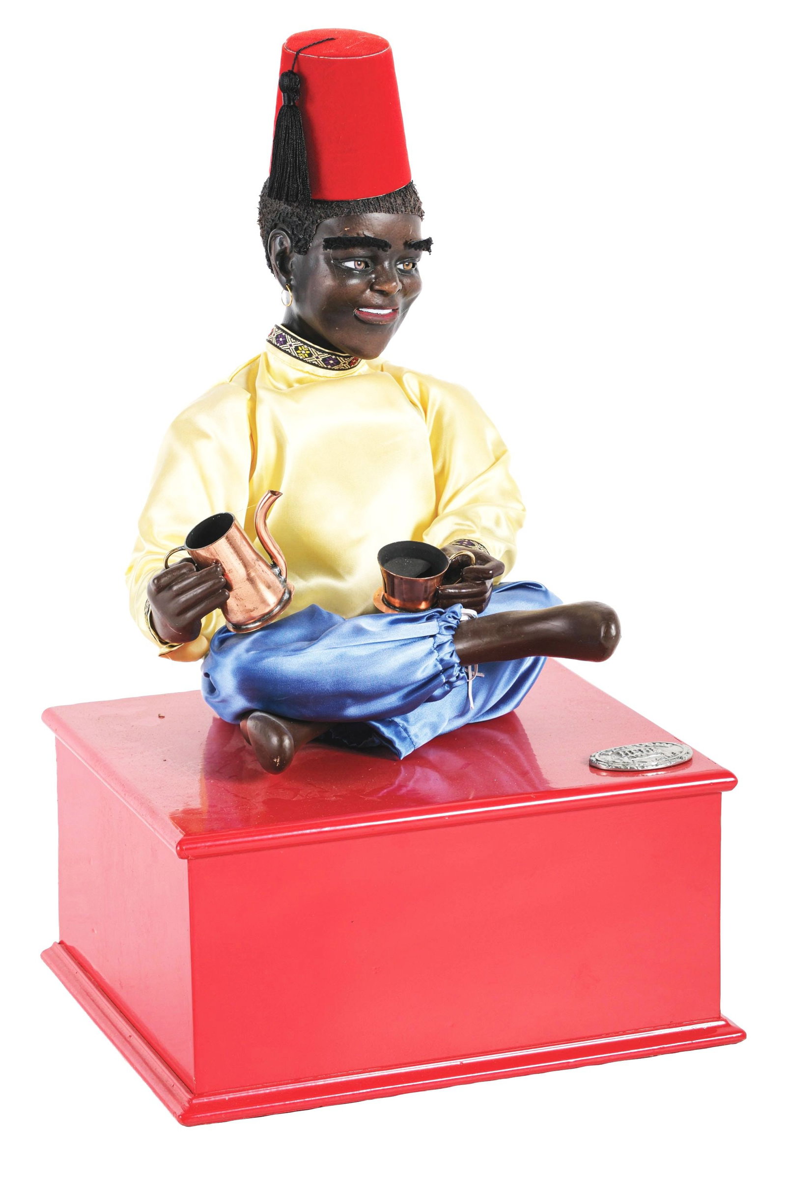 ELECTRIFIED AUTOMATON OF A TURKISH GENTLEMAN POURING COFFEE: This electric automaton has a coin entry to trigger the operation, where the gentleman sitting cross-legged on the box will raise his hands, move his head and attempt to pour coffee into his cup. COND