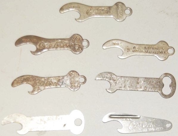 Lot of 7:Coca-Cola Bottle Openers.: Medium wear and surface rust. Condition (Very Good). Size Largest: 2 - 7/8" L.