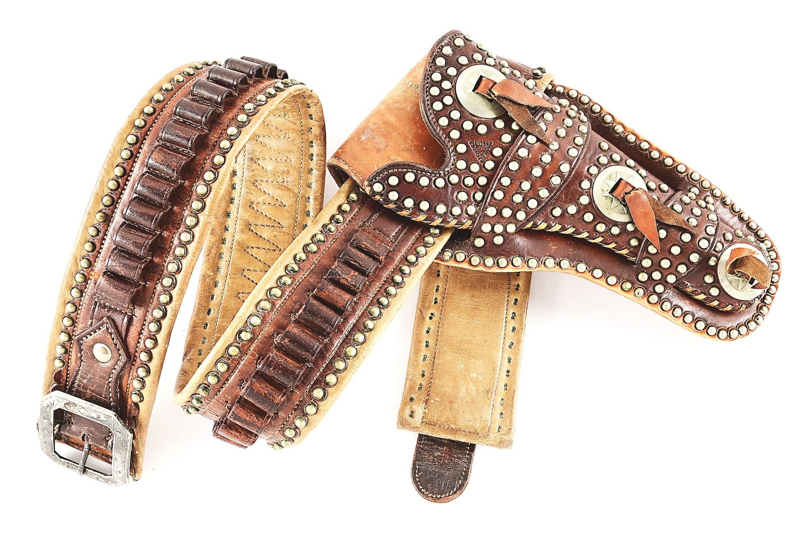 MATCHING HOLSTER AND BELT BY R. T. FRAZIER, PUEBLO, COLORADO.: A profusely nickel studded cowboy cartridge belt and holster set. Double loop Mexican pattern holster bears a deep recurve throat pattern with closed toe and a buck stitched edge. Three star-pattern n