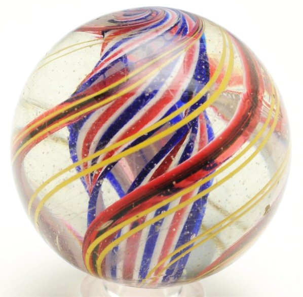 3-Stage Divided Core Swirl Marble.: Red, white, and blue divided core is surrounded by translucent red and green bands. Outer decoration consists of groups of two yellow latticino threads. Several as-made hot spots. Nice faceted pontil.