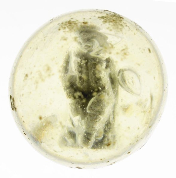 Boy Sitting on Stump Sulphide Marble.: Depicts boy it hat sitting on a stump with crossed legs. Surface has some chipping and wear. Condition (8.7). Size 1 - 9/16"" Dia."