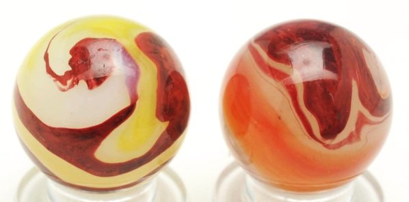 Lot of 2: Akro Agate Oxblood Marbles.: Includes one white base egg yolk oxblood and one carnelian oxblood with wide pattern of oxblood and orange. Condition (9.5 - 9.7). Size Each: 23/32"" Dia."