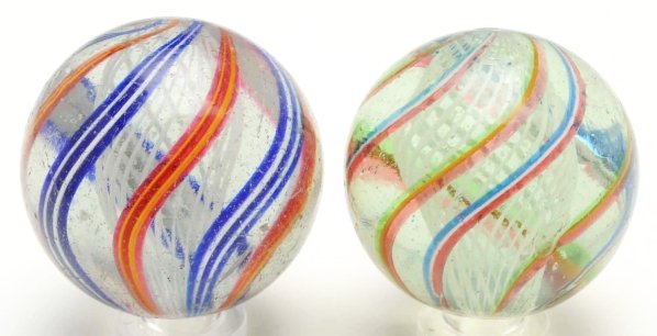 Lot of 2: Large Latticino Swirl Marbles.: The smaller marble is a white latticino core with alternating red, white, and blue bands with translucent red, green, and opaque yellow bands. The larger marble is a white latticino with alternating w