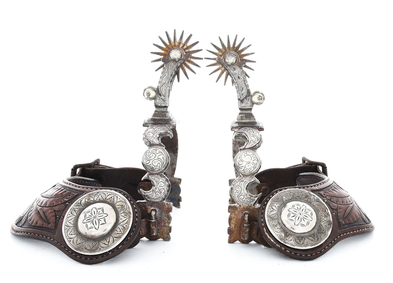 CRESCENT MOON INLAID SPURS: Unmarked, finely engraved 1960s California-style spurs with 1 3/4", 20-point spoke rowels and great floral carved leathers adorned with 2" engraved domed conchos. Excellent condition. Provenance: Ex G