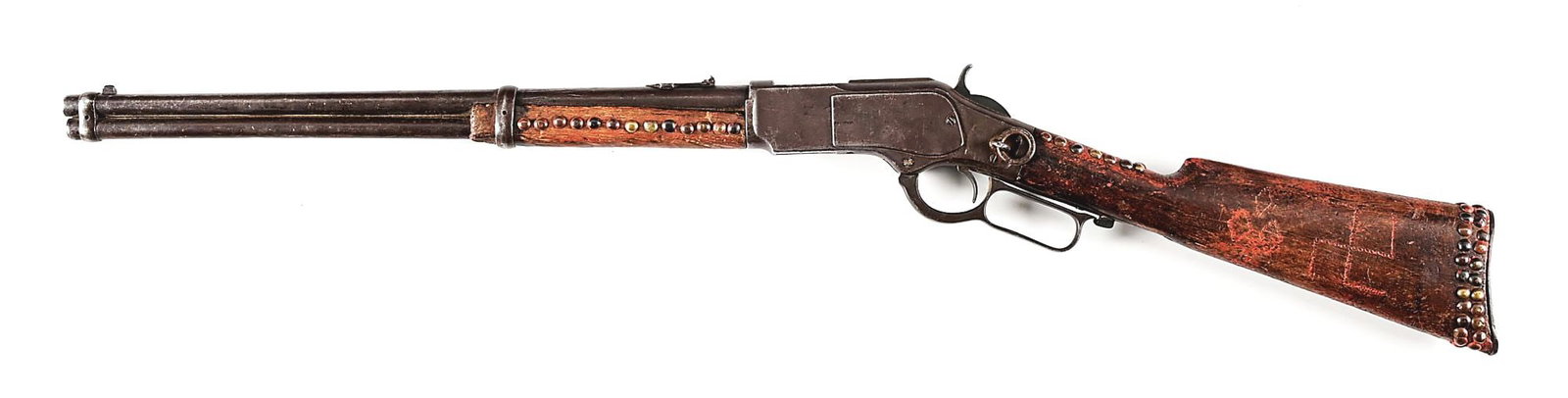 (C) INDIAN TACK DECORATED WINCHESTER MODEL 1873 SADDLE RING CARBINE: SERIAL 134458B. MFG 1883. CALIBER 44WCF. 3rd Model. Standard 20" barrel, full magazine, dove tail front sight, folding leaf express rear sight, walnut stock, replaced butt plate saddle ring & stud. He