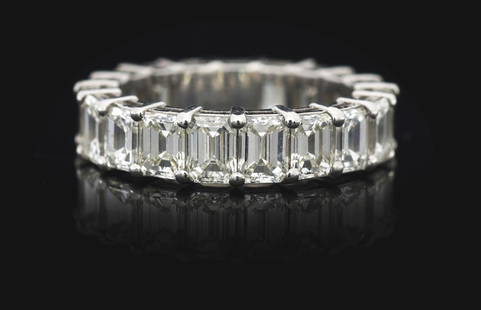 LADIES' PLATINUM 6.70CT EMERALD CUT DIAMOND ETERNITY BAND: Ladies' platinum and diamond eternity band consisting of 19 prong-set emerald cut natural diamonds with a total weight of 6.70cts, graded H/I color, VS clarity. Finger size 6 1/4. Width 5.25mm. Gross