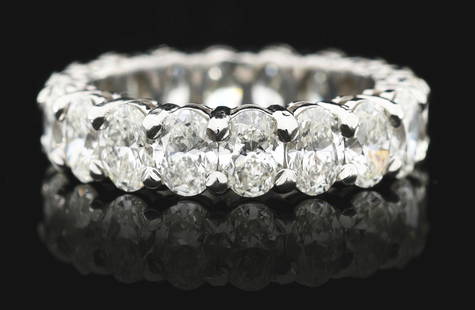 LADIES' PLATINUM OVAL DIAMOND ETERNITY BAND: Ladies' platinum and diamond eternity band consisting of 18 prong-set oval cut natural diamonds with a total weight of 5.75cts, graded H/I color, VS clarity. Finger size 6 1/4. Width 5.25mm. Gross