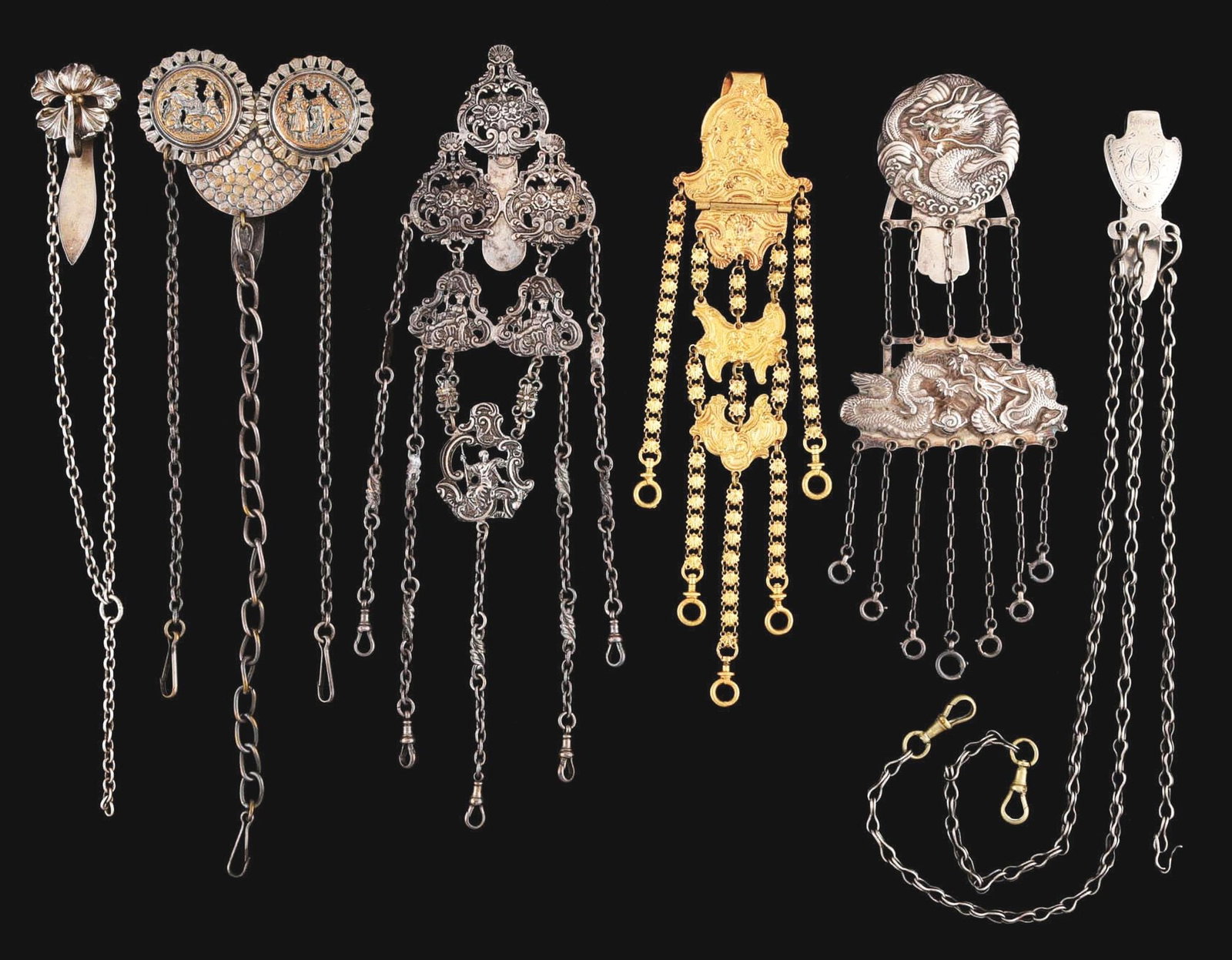 LOT OF 6: CHATELAINES W/ CHAINS: Lot of six chatelaines include one of coin silver, two silver color, one with dragons, one gold color with lady and child and one with people and flowers. No damage or repairs. Condition: (Excellent)