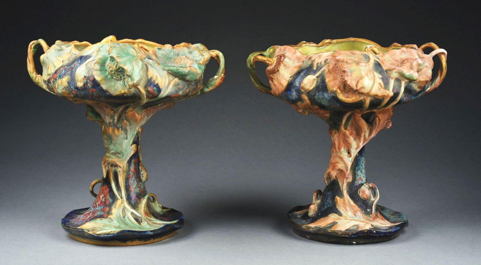 LOT OF 2: AMPHORA FOOTED GLAZED EARTHENWARE POPPY CENTERPIECES W/ EXTRUDED STEMS: C. 1900. Blue, green and rust glazing with applied gold gilt. (A) Amphora oval, crown, Austria oval, impressed "8654," "42." CONDITION: Very good, with a few small areas of glaze loss. (B) Crown, amph