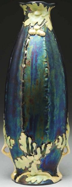 Tall Heliosine Ware Iridescent Ceramic Vase.: Austrian. Applied leaves and acorns in shades of green against a metallic blue body. Condition (Mint). Size 15 - 3/4" T.