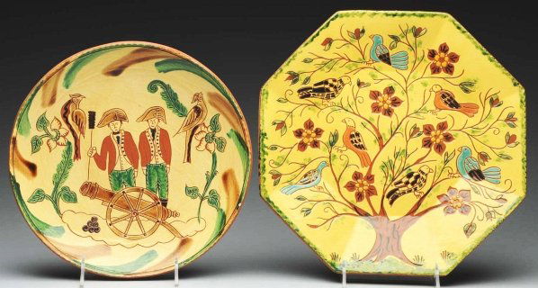 Lot of 2: Lester Breininger Redware Chargers.: Includes one depicting Colonial men shooting a cannon and one octagonal charger with birds in tree. One glaze chip to the rim of the charger with Colonial men. Condition (Excellent - Near Mint Plus).