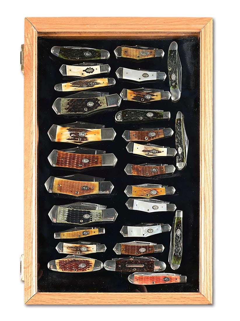 LOT OF 27: CRIPPLE CREEK FOLDING KNIVES IN WOOD AND GLASS LOCKING DISPLAY.: Largest knife in group is a stag handled 2 blade Eureka Hunter that measures 4 - 1/2". The highlights of the group are 5 Eureka pattern folding hunters, a very old pattern that is rarely reproduced an