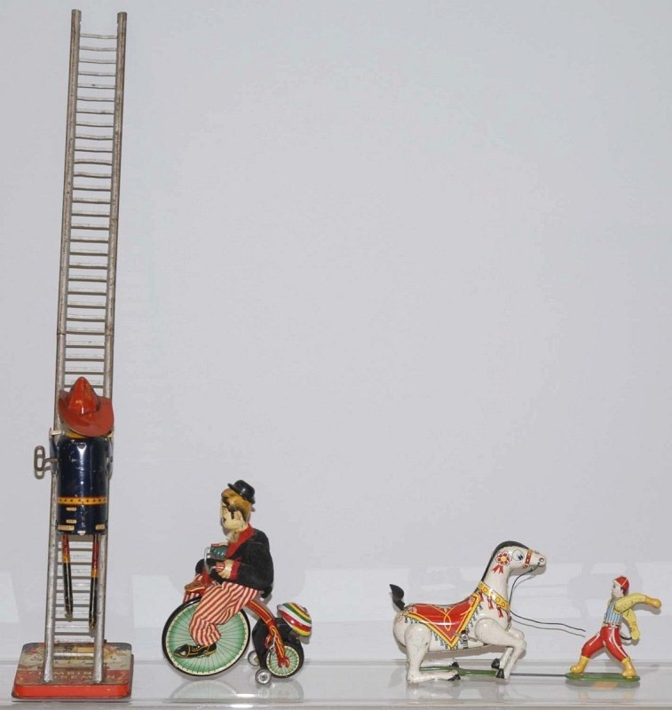 Lot of 3: Tin Litho Wind-Up Toys.: Both American and Japanese toys. Includes a TPS Gay 90s Cyclist, a CK horse trainer toy and a Marx climbing fireman with a late ladder and stand. Condition (Good - Very Good). Size Largest: 22" T. Lar