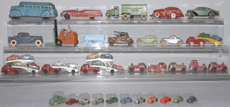 Large Lot of Vintage Vehicle Toys.: Includes several nice Tootsietoys, a long distance hauling tractor trailer, several small cars, one pressed steel bus, one tin wind-up Marx taxi toy, and a lot of slush mold and Barclay figures. Condi