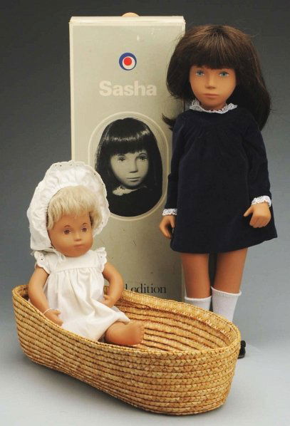 Lot of 2: Sasha Dolls.: Both made in England. Sasha baby girl with blonde hair in original white dress, panties, and hat with wrist tag and basket. Sasha #180 limited edition 1980 girl, all original in velvet dress with wris