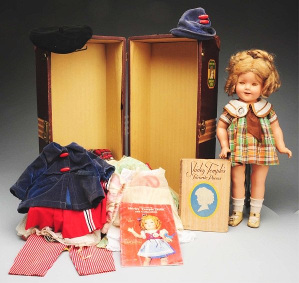 Ideal “Shirley Temple” with Trunk.: Composition doll fully marked “Shirley Temple” on head and body, lashed sleeping eyes (crackled), original blonde mohair wig in original set with brown ribbon (a little squashed in back), open mou