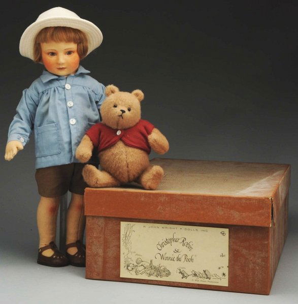 R. John Wright “Christopher Robin” Doll.: All-felt doll with molded features and mohair wig in original blue coat, brown pants and white hat along with jointed “Winnie the Pooh” both with original labels #414 of limited editions. Original