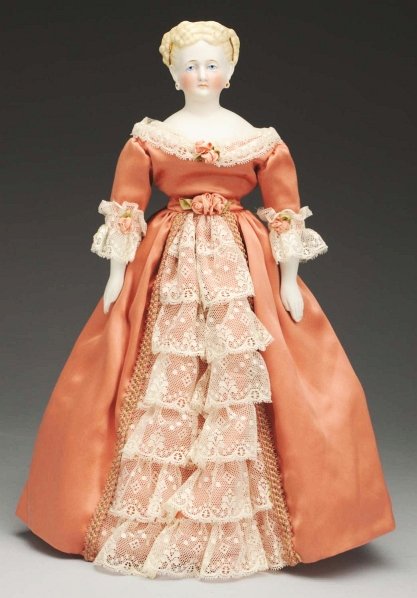 Elegant German Parian Lady Doll.: Shoulder head with fancy molded blonde hair with curls at side pulled back into a cluster of curls at back and embellished with gold and black molded ribbons, brown tapered eyebrows, molded eyelids wi
