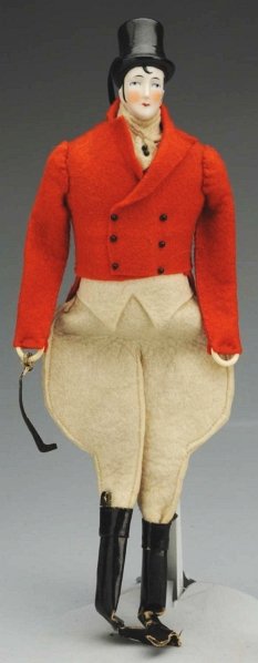 China Head Equestrian Man in Felt Outfit.: 1920s. Adult china head with molded black top hat, long thin face and nose, tiny painted eyes with black eyelash line, Pierrot-type side burns and forehead curl, cloth stuffed torso with red felt ridi