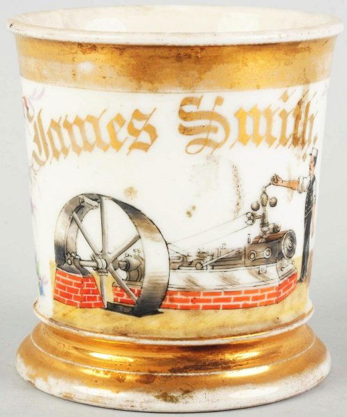 Steam Engine Machine Shaving Mug.: Has name, "James Smith" across top in gold gilt, a beautiful floral wrap on both sides of handle. Stamped, "T&V" under base. Includes a nice image of a man oiling a steam driven machine. Some wear to
