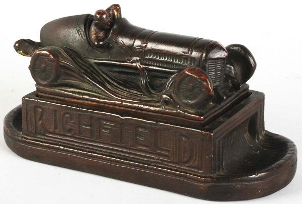 Copper Over Plaster Richfield Oil Desk Caddy.: 1930s. Retains the original patina. Race car comes off at the base revealing a pencil/pen box in the base. The neck of the racer has been professionally restored. Scarce. Condition (Very Good). Size 9