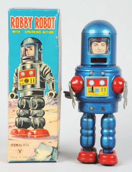 Tin Litho & Painted Wind-Up Robby Robot.: Japanese. Made by Yonezawa. Working. One slight bend in one of the arms. Includes original box with some clean punctures to the face and almost no missing paper litho. Box also comes with its original