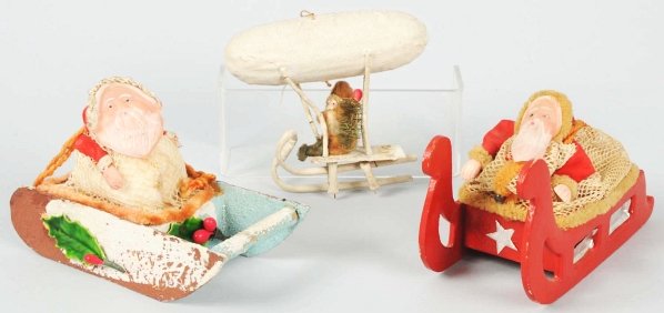 Lot of 3: Santa Claus Toys.: Two have celluloid face and are riding in a sleigh and the third is a zeppelin blimp with Santa. Needs to have one rung reattached. Easy to replace. Condition (Excellent). Size Largest: 5 - 1/2" L.
